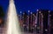 Many flags on flagpoles with lamps at night at Ouchy, Switzerland. Fountain frontview. Motion blur