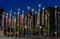 Many flags on flagpoles with lamps at night at Ouchy, Switzerland. Motion blur