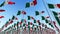 Many flags of Mexico waving against blue sky