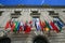 Many flags of the world on the facade of a historic building