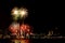 Many flashing fireworks with night cityscape background celebrate New Year.