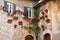 Many flower pots with blooming cyclamen on the wall of an old stone house