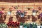 Many flower pots with petunia hanging against brown wooden house wall.