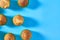 Many fluffy muffins in green paper molds scattered on blue background. Top view