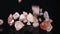 Many Fresh Raw Whole Pink Himalayan Salt Pieces Falling at Black Background. Healthy Superfood