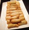 Many fried Spring Rolls on a big white plate