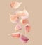 Many garlic cloves falling on beige background