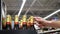 Many glass beer bottles in golden foil close-up and a male buyer\\\'s hands takes a couple