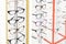 Many glasses rows at optical retail store. Rich assortment choice of different eyewear frames on eyeglasses shop display