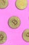 Many golden bitcoins lies on a blanket made of soft and fluffy light pink fleece fabric. Physical visualization of virtual crypto