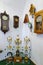 Many gorgeous antique watches hanging on the white wall and standing on the bottom of the glass case