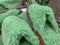 Many green fluffy fuzzy home slippers in a shop, shopping for comfort cozy home