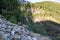 Many hard sharp rocks with pine forest on horizon