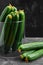 Many harvest cucumbers In vase on the grey concrete background. Top view