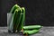 Many harvest cucumbers In vase on the grey concrete background. Top view