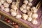 Many heads of garlic drying in a wooden box