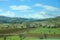 Many of the hills in the background of plowed fields and meadows