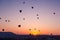 Many huge balloons are flying in the air at the sunrise. Cappadocia, Turkey.