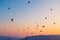 Many huge balloons are flying in the air at the sunrise. Cappadocia, Turkey.