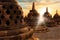 Many huge stone Buddhist stupas against the background of the sunrise with rays of light in the Borobudur Temple. Java island. In