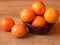 Many juicy orange shiny ripe grapefruit fruit in a basket on oak tree background. Retro rustic style. Wallpaper or background.
