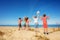 Many kids jump on the sand beach looking to sea