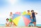 Many kids in large group behind beach umbrella