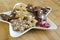 Many kinds of Christmas cookies on white plate, gingerbread dark and light, star shape dish, bamboo wooden background