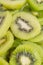 Many kiwi slices are placed in a glass crisper. Kiwifruit slices without peel