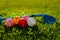Many light colorful practicing plastic golf balls with holes and one golf club lays together at green grass. Practicing golf at