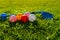 Many light colorful practicing plastic golf balls with holes and one golf club lays together at green grass. Practicing golf at