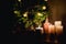 many lighted candles near the Christmas tree. Photo in dark colors. Copy space