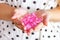 Many little pink hearts in Caucasian woman hands on light background. Valentines day celebration, romantic feelings and altruism