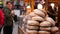 Many loaves of bread are sold at the market counter. People choosing bakery products at festive fair on a winter evening