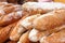 Many loaves of bread stacked in a market environment