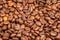 Many macro coffe beans on coffee background.