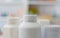 Many medicine bottle with blur shelves of drug