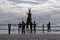 Many men carry the Straw Scarecrow into the water during a ceremony for good weather and good fishing, at sunset