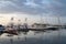 Many motorboats and sailboats Docked at a Marina on dramatic sunrise background