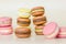 Many multi colored macaroon cakes in stacks on a light background