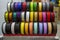 Many multi-colored spools coils of thread of filament for printing 3d printer.