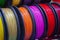 Many multi-colored spools coils of thread of filament for printing 3d printer.
