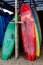 Many multi-colored surfboards in a row