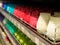 Many multicolored colorful red orange yellow paraffin stick candles arranged in black shelves lying on shelter and sorted by color