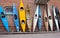 Many old time vintage kayaks stacked against the wall