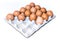 Many orange farm spotted brown chicken eggs in carton open box container on white backdrop