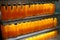 Many Orange juice glass bottles on freezer shelves at supermarket.