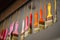 Many orange, red, pink color brushes hang on ropes from ceiling