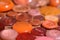 Many orange sewing buttons on a wood table