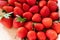 Many organic strawberries background shows red berries with seeds as food background for healthy nutrition, seasonal fruit